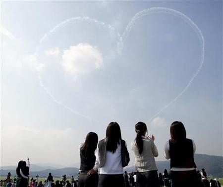 Students watch as the Black Eagles, South Korea's Air Force special flight team, perform during Seoul Air Show 2005 media day at the Seoul Military Airport, south of central Seoul October 17, 2005.